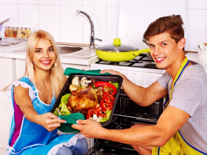 عکس با کیفیت دختر و پسر جوان کنار فر با ظرف مرغ سوخاری